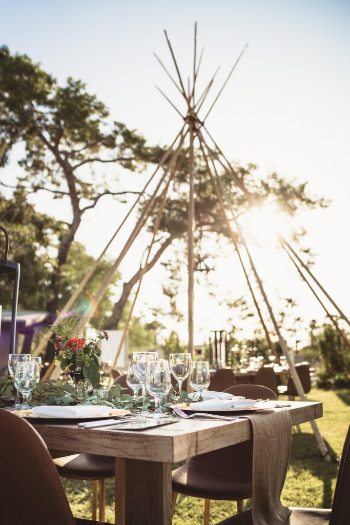 A teepee set up in a backyard with a beautiful tablescape.
