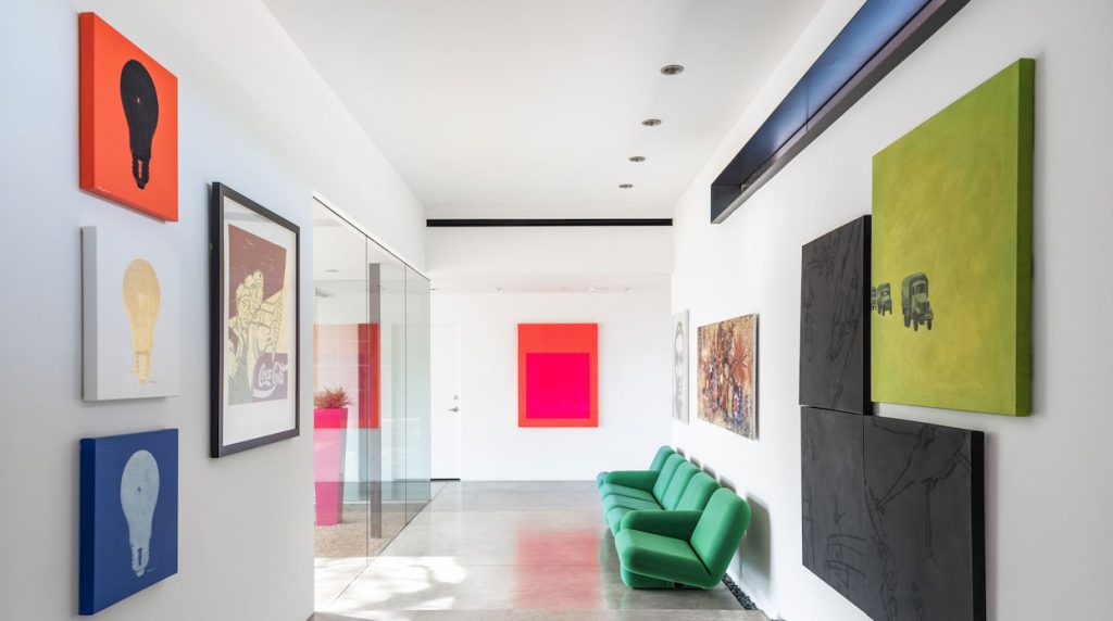 Light-filled hallway full of bright artwork