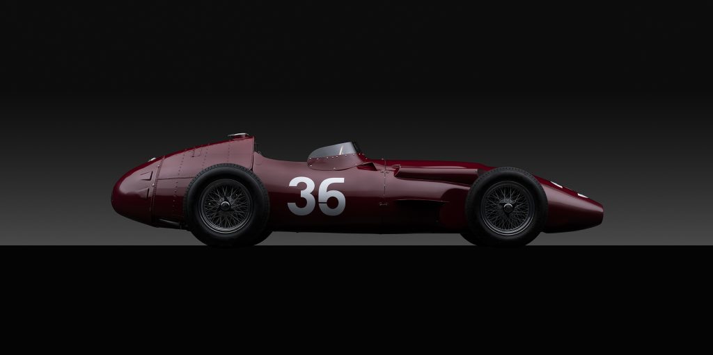 A red Maserati photographed dramatically against a black background