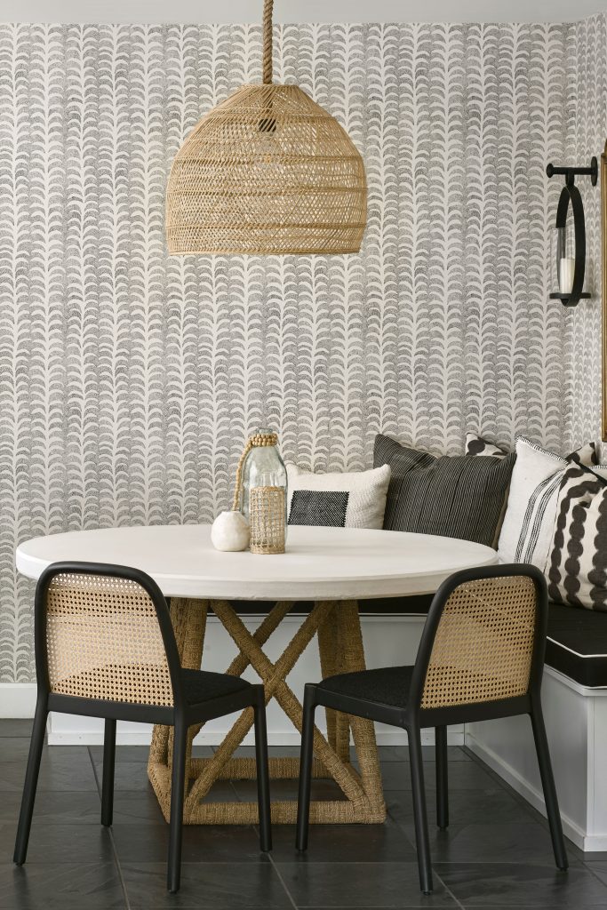 A breakfast room area with a table, chairs and textured wallpaper
