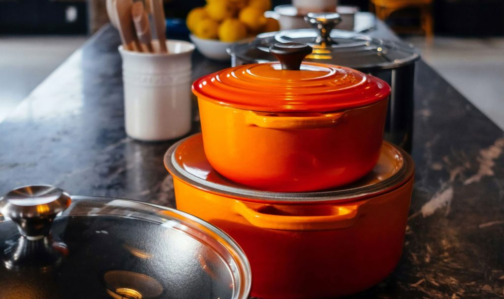 Stacked orange pots on a marble countertop