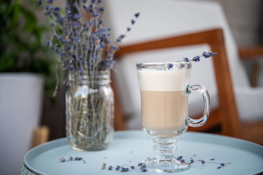 A lavender cocktail with a mason jar of fresh lavender