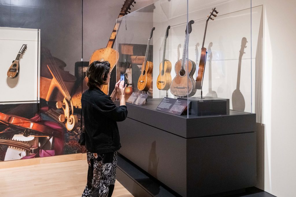 Woman looking at guitars in a glass case