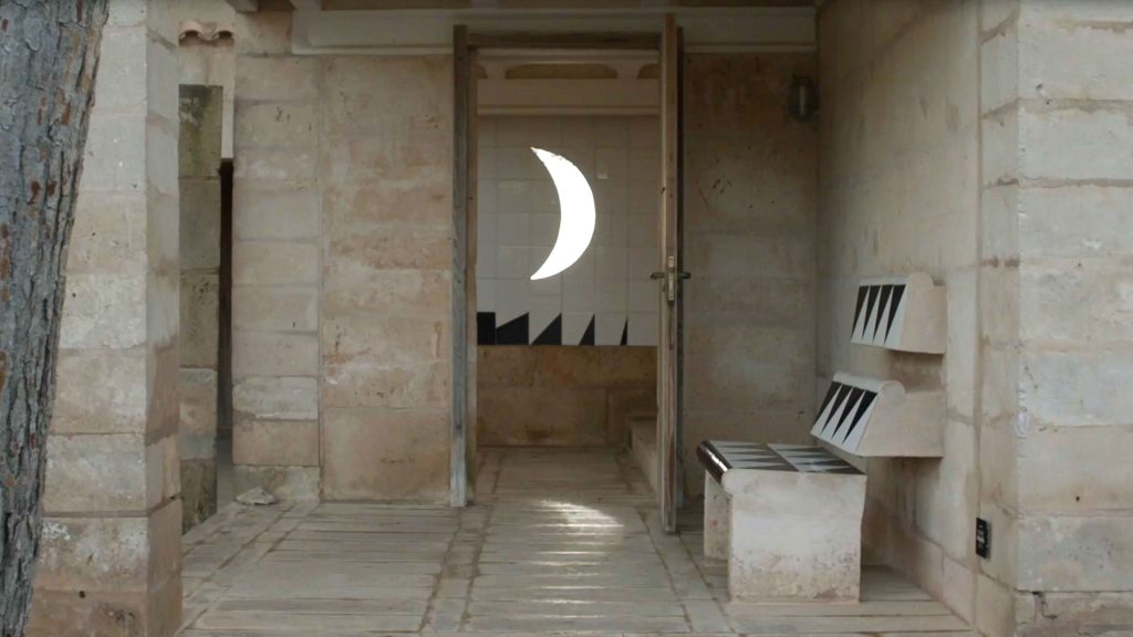 Columns of a building with a moon-shaped cutout window