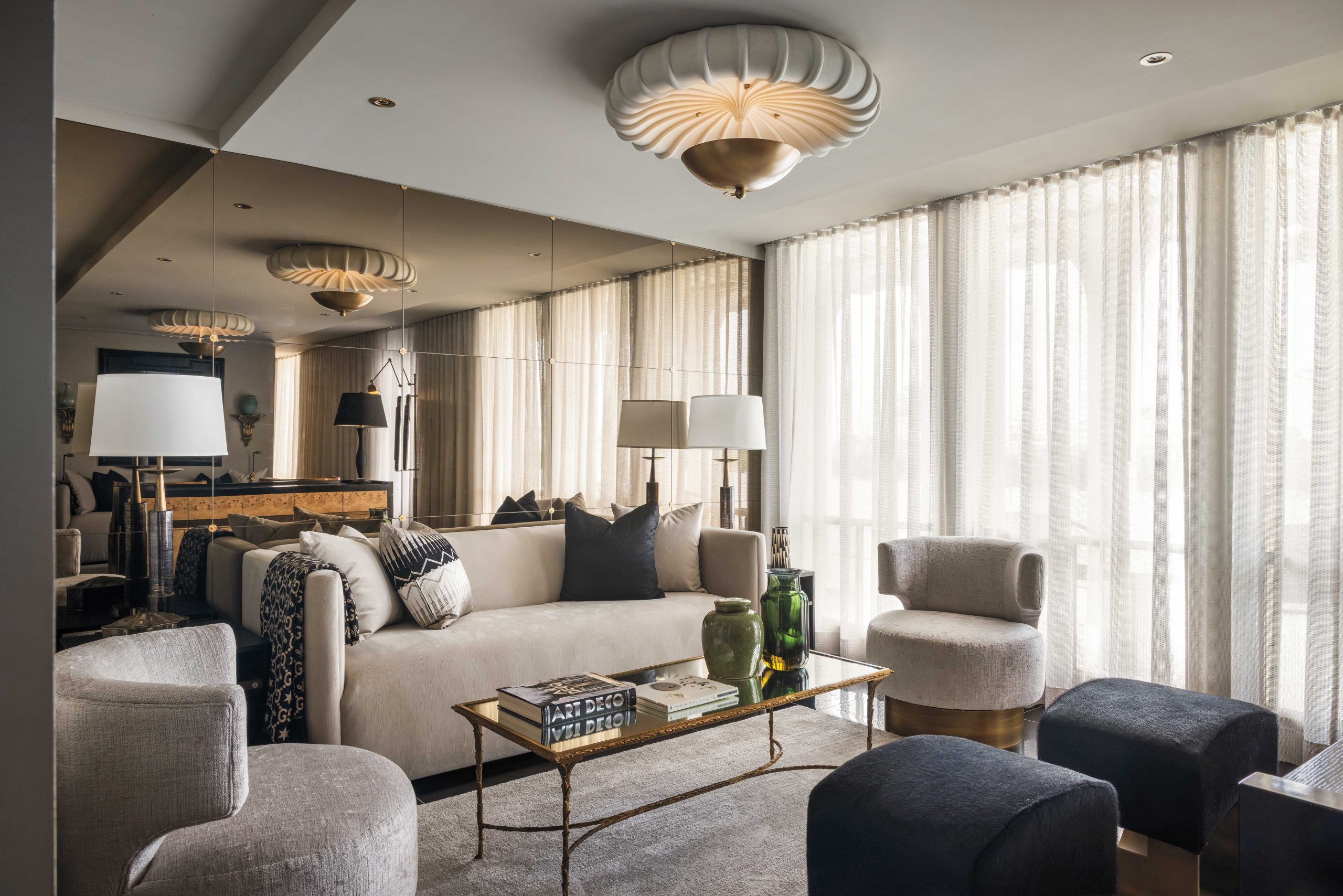 A bronze-faceted mirror with gold rosettes adds elegance and expansiveness to interior designer James McIntyre’s penthouse living room. “It would have been typical in the ’60s, the era of the building,” he says. A ripple fold turns cement-colored waffle-sheer draperies into an architectural feature. “The sheers filter southern light, but also create a dramatic effect because we’ve done it wall to wall,” McIntyre explains. “It’s theatrical.”
