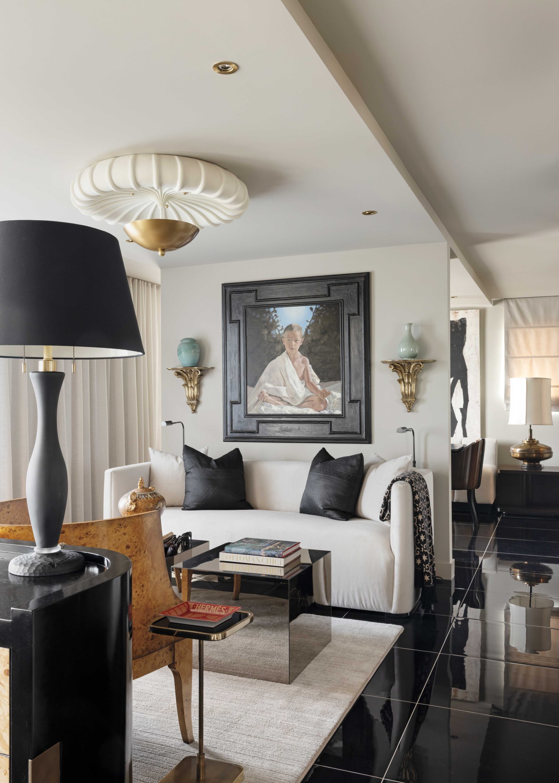 A favorite portrait by McIntyre’s friend, Canadian painter Janine Hall, anchors the western side of the living room. The designer’s mélange of influences—art deco, Depression Modern, old Hollywood and Asian art—are on display here, along with his penchant for a certain color. “I’m like Karl Lagerfeld,” he shares. “I can’t live without black.” McIntyre visited a number of markets in Thailand to source ebony silk for the pillows.