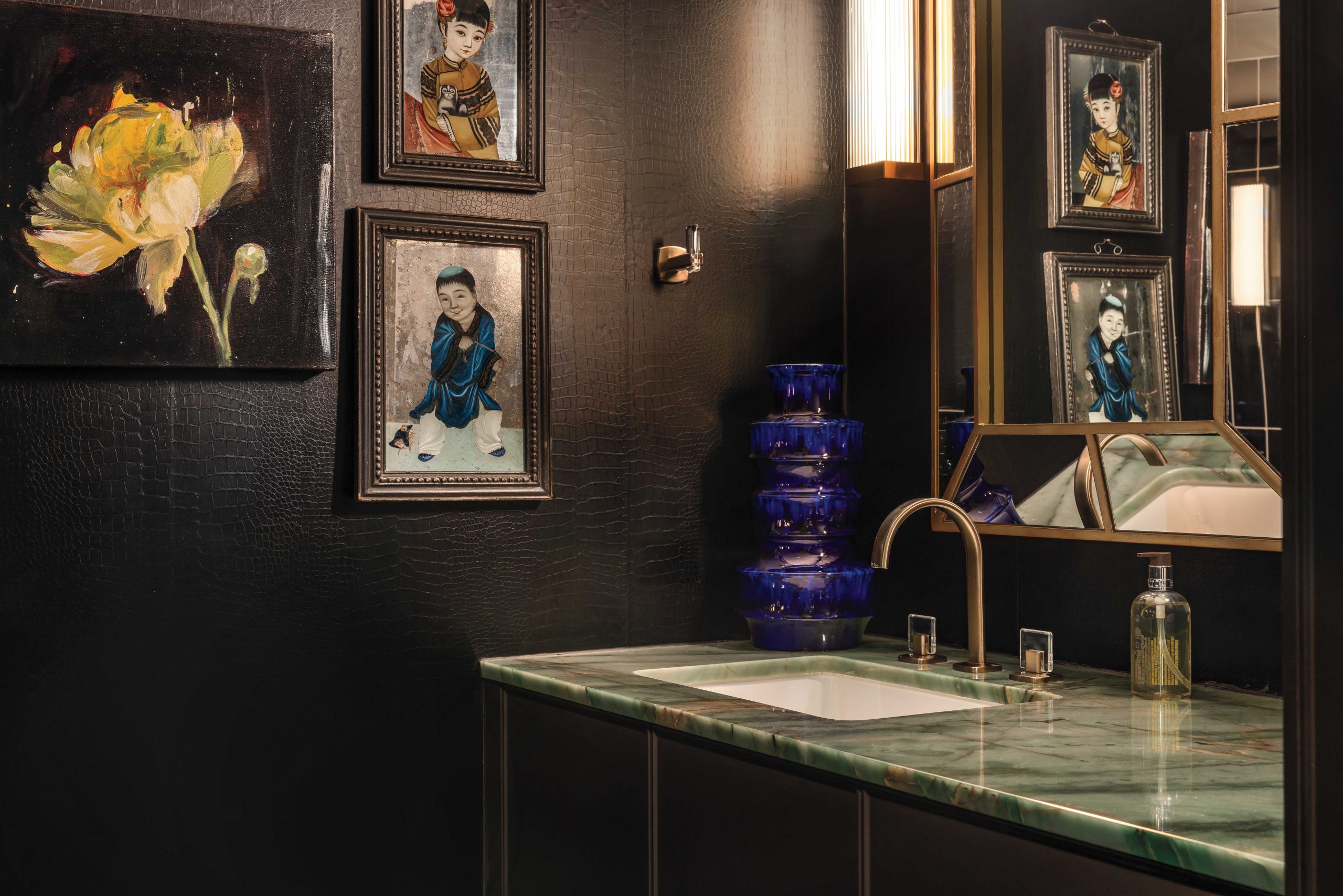 “Don’t be afraid of going dark, dramatic and moody in a powder room,” McIntyre advises. “It’s a good chance to make a dramatic wallpaper statement, like with this black faux alligator paper.” The peony painting and back-painted Chinese antiques “give you something to look at and a reason to pause.”