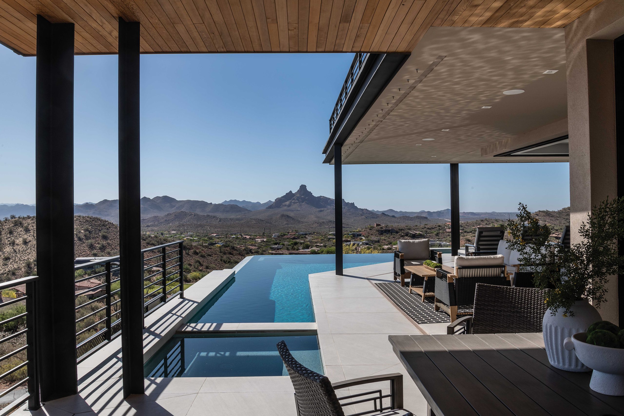 On the main level just outside the great room’s retractable glass walls, a negative-edge pool looks at Red Mountain in the distance.