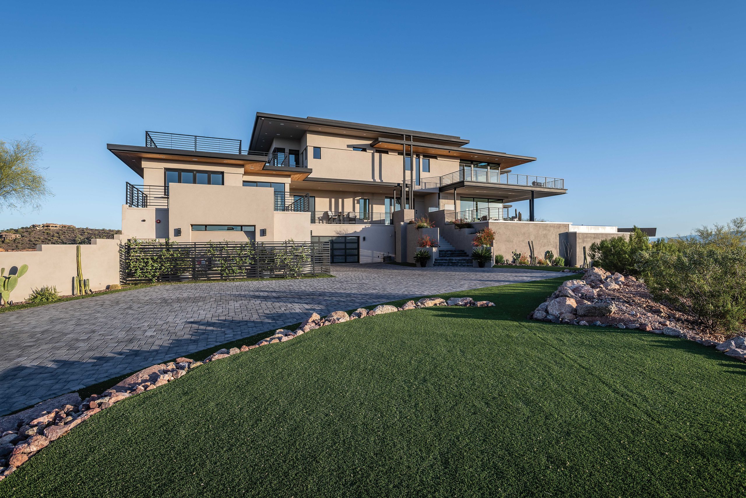 The three-story, 9,000-square-foot home sits atop one of Fountain Hills’ highest peaks. Garages, a home office and live-in suite comprise the ground floor; the main level includes the kitchen, dining room, great room, powder room, guest suite and a game room accessible from outside. The upper level includes the primary suite and two bedrooms. The home is off the grid, with solar-powered electricity.