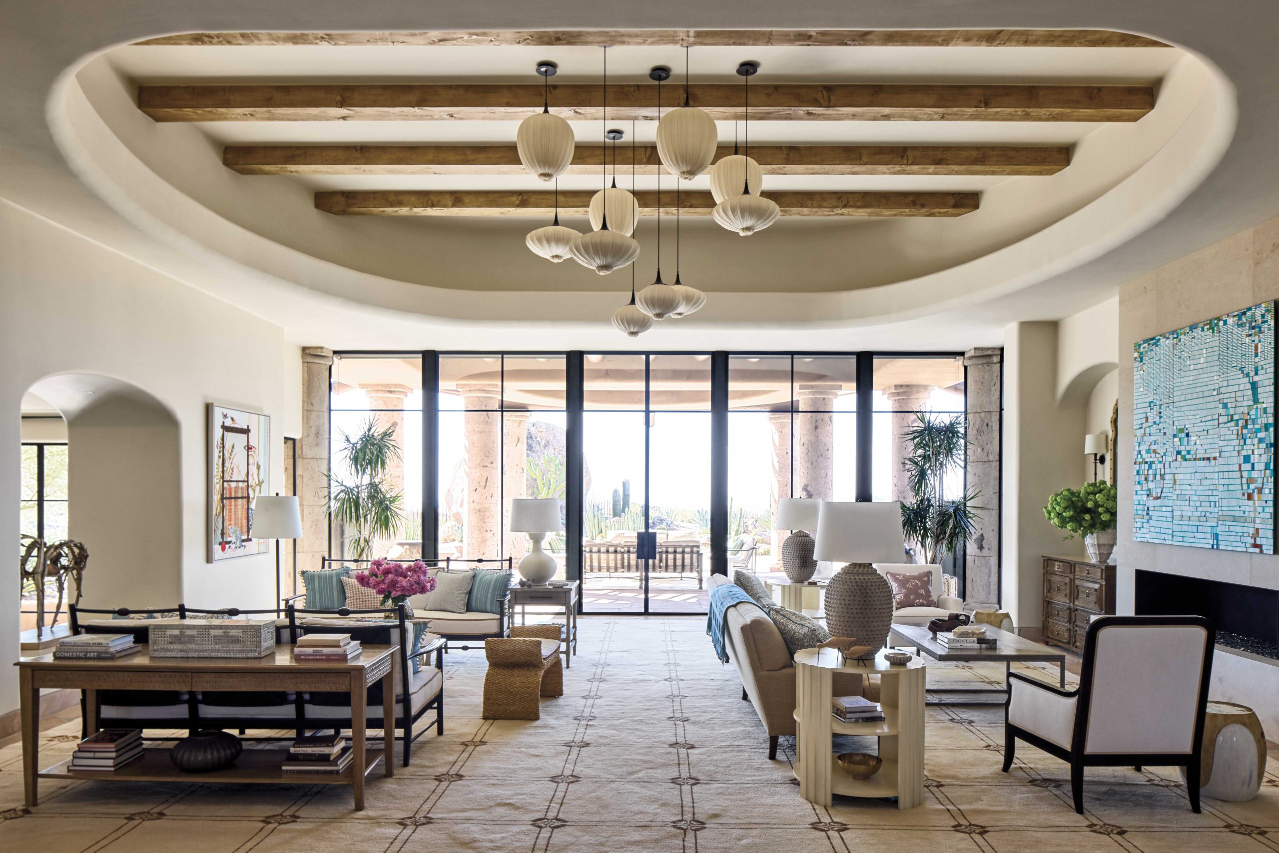 Architect Craig Wickersham eliminated many of the home’s original architectural details to simplify and modernize the interior, including stripping the living room ceiling of heavy vigas and latillas. New steel-framed windows and doors flood the interior with daylight. Interior designer Ashley Sharpe brought the voluminous living room down to human scale by creating two seating areas, unified by a large area rug and a new ceiling light installation. Her overarching goal for the house was to create a sense of relaxed intimacy. “It’s a big house,” she says, “so you have to look for small moments, for coziness. You don’t want to make a sterile cavern.”